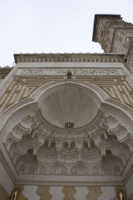 The main entrance (partly, left) and the 50 meters high minaret, Seljuk, built in 1075. It survived an earthquake that gave it a lean, and saw the mosque burn down in 1169.Aleppo 8 APR 2009
